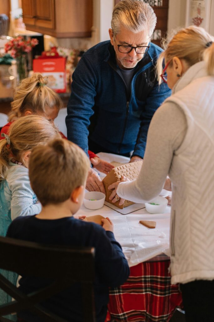 A family spends valuable time together creating a gingerbread house.