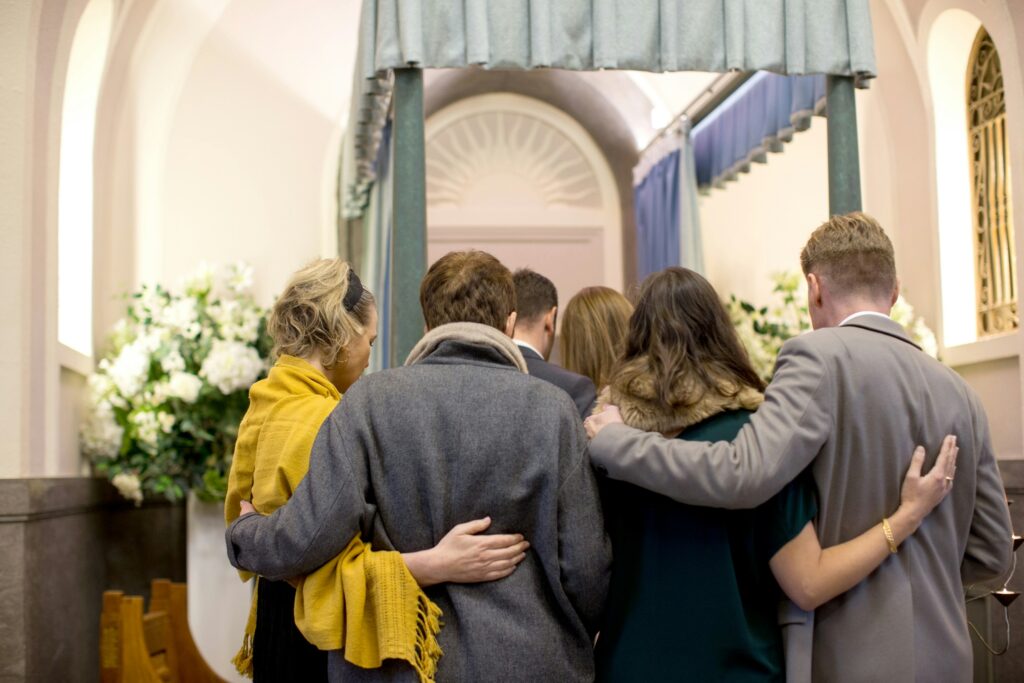 A family hug and console each other at a funeral.