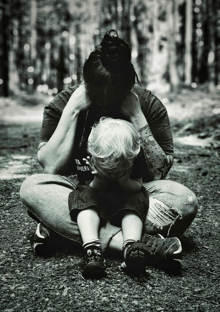 A child sits in his mother's lap as they grieve.