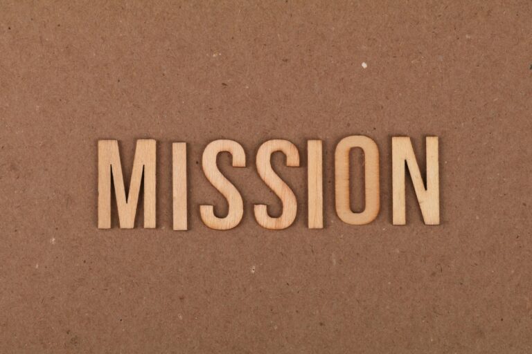 Wooden letters spelling "MISSION" on a textured brown background.