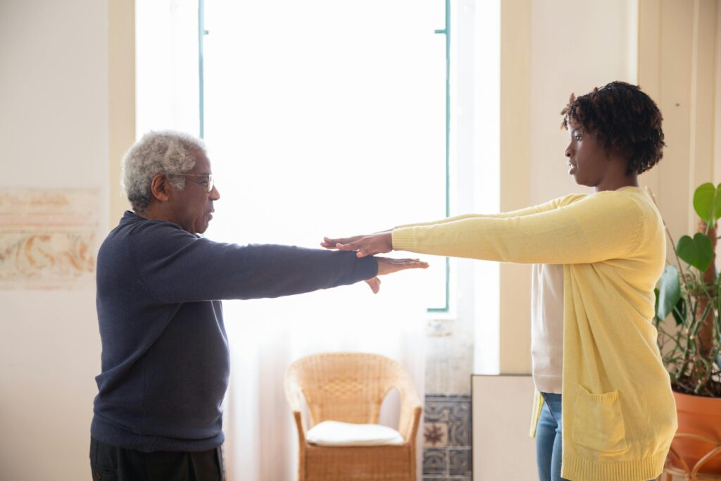 A woman helps her mother exercise.