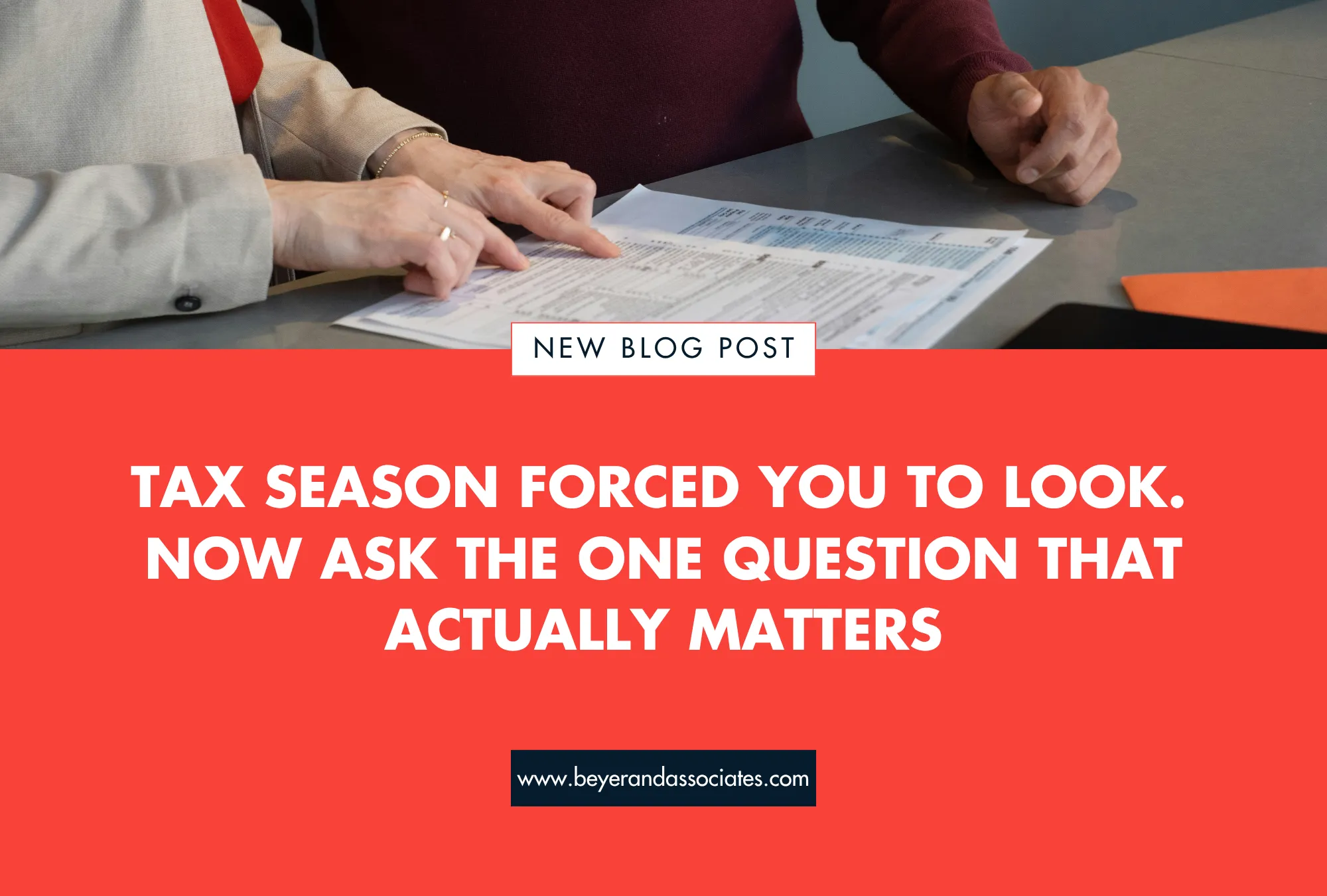 Two people reviewing tax documents on a gray table, with bold red text below.